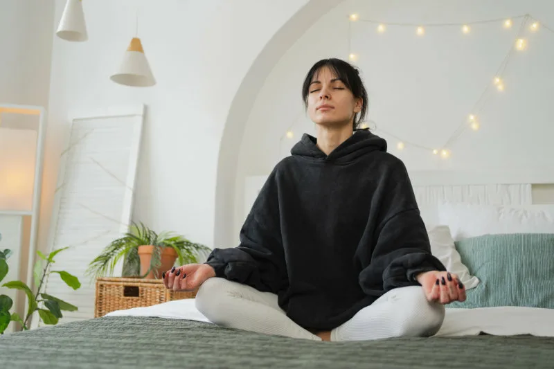 Frau meditiert im Alltag mit Inner Smile Meditation im Sitzen und findet innere Ruhe ohne Dogmen